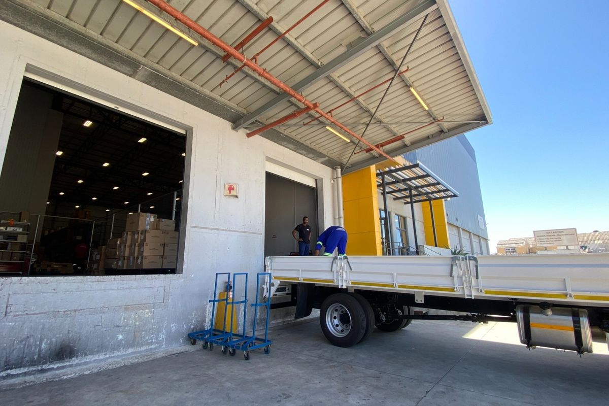 Industrial loading bay area featuring a concrete hardstand, metal canopy, and roller shutter access for efficient goods handling and logistics operations.