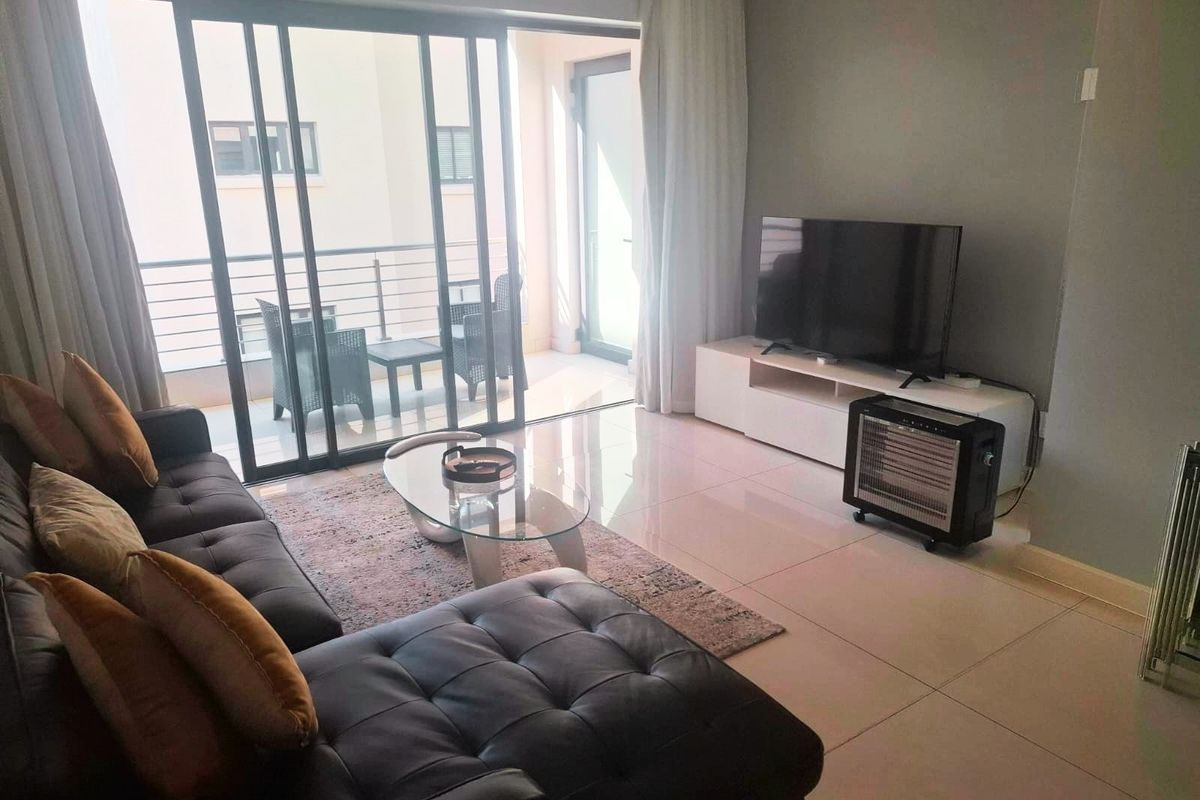 A bright living room featuring large sliding glass doors that provide seamless access to an outdoor balcony area.