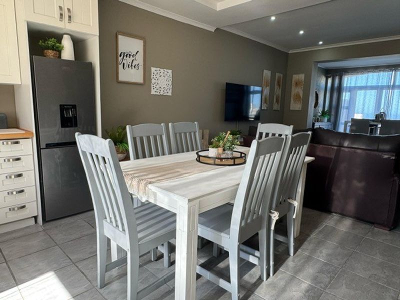 Open-plan living and dining area featuring tiled flooring, recessed lighting, and a functional kitchen layout with integrated cabinetry.