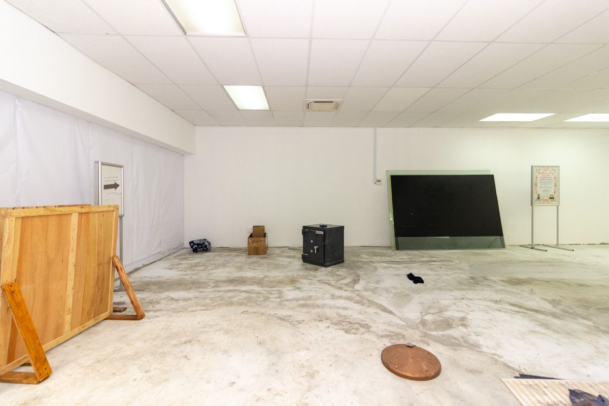 An open-plan utility or retail space featuring a suspended ceiling with recessed lighting and unfinished concrete flooring, suitable for various commercial fit-out options.