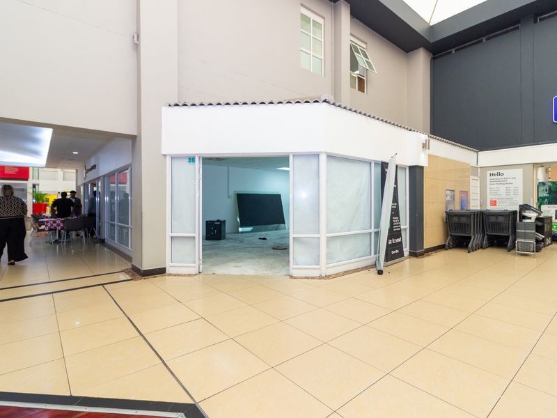 A vacant retail unit located within a shopping center, featuring a glass storefront, tiled flooring, and neutral wall finishes, ready for new tenant fit-out.