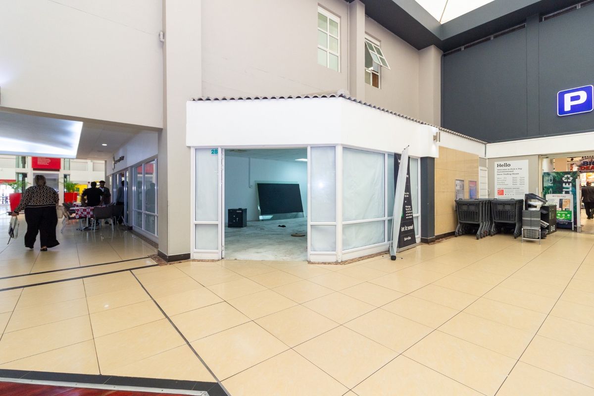 A vacant retail unit located within a shopping center, featuring a glass storefront, tiled flooring, and neutral wall finishes, ready for new tenant fit-out.