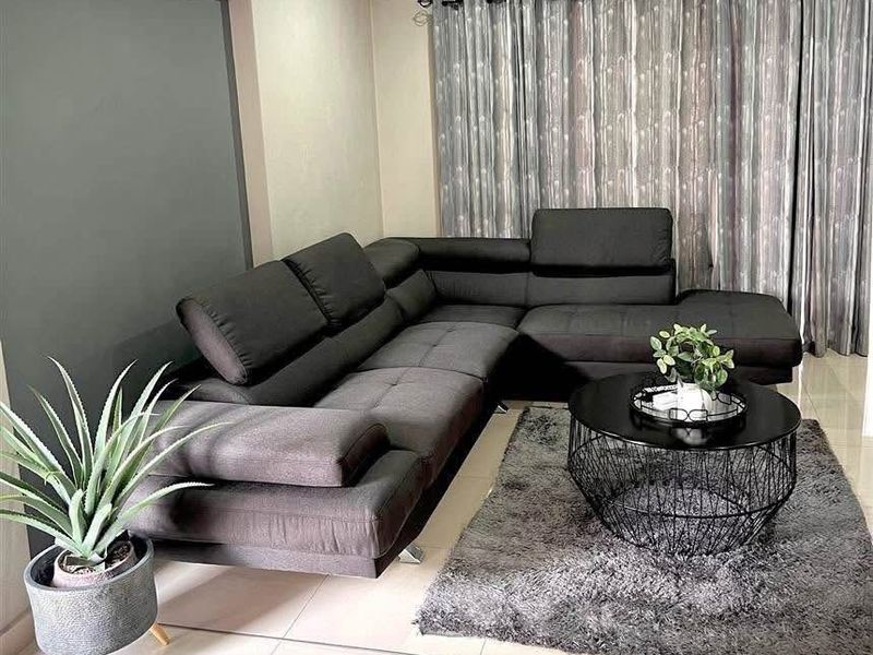 A well-maintained living room featuring tiled flooring, a wall-mounted split-system air conditioner, and neutral wall finishes.