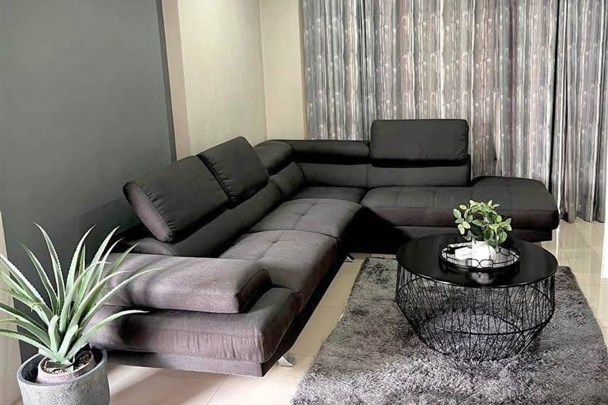 A well-maintained living room featuring tiled flooring, a wall-mounted split-system air conditioner, and neutral wall finishes.