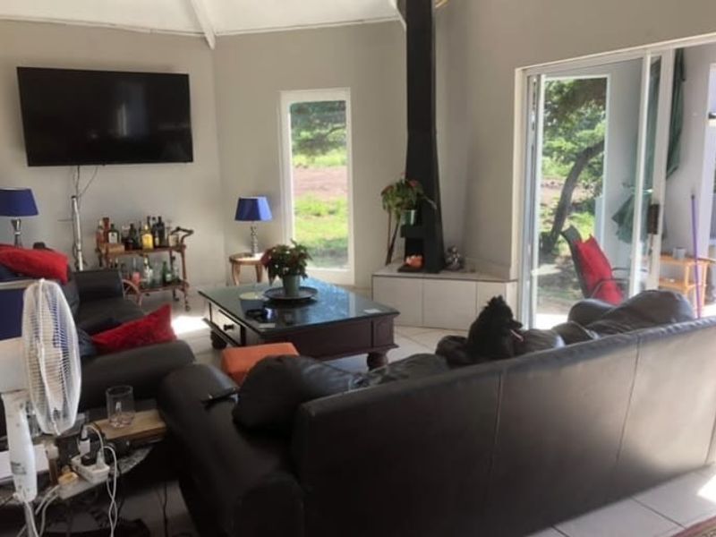 Spacious living room featuring a modern freestanding fireplace, tiled flooring, and large sliding glass doors providing access to the outdoor area.