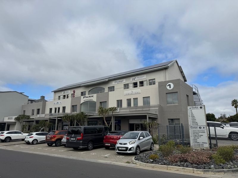 Front elevation of Park Central office building featuring multi-tenant signage, paved parking, and external architectural details.