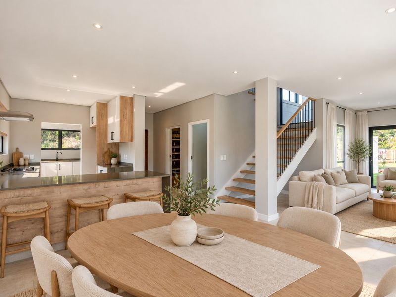 Spacious open-plan living area featuring a modern kitchen with island, dining space, and staircase, finished with high-quality materials and abundant natural light.