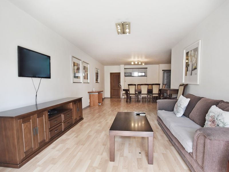 Spacious open-plan living and dining area featuring light laminate flooring and neutral walls, providing a versatile layout for comfortable living and entertaining.