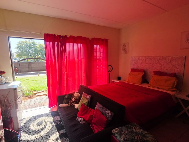 A bedroom featuring tiled flooring and a sliding glass door providing direct access to the garden area.