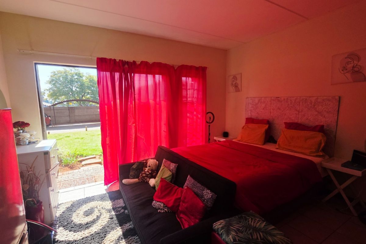 A bedroom featuring tiled flooring and a sliding glass door providing direct access to the garden area.
