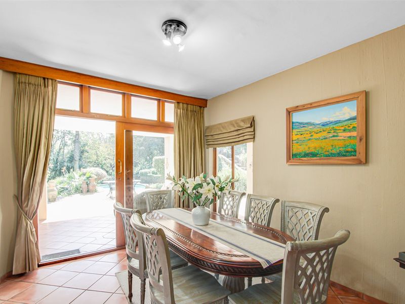 Dining room featuring terracotta floor tiles and large timber sliding doors providing direct access to the outdoor patio and garden area.