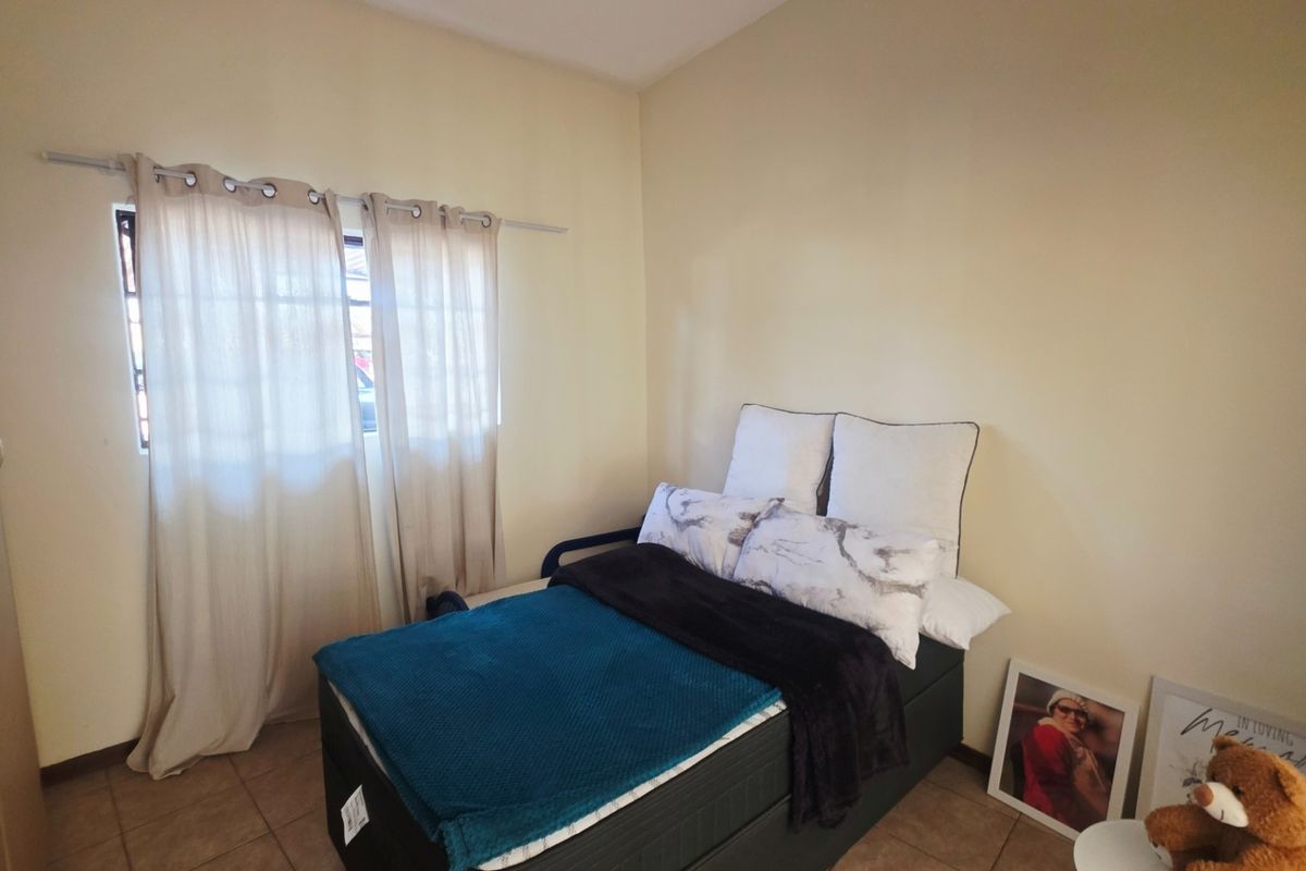 A functional bedroom featuring tiled flooring and a built-in wardrobe, providing essential storage space.