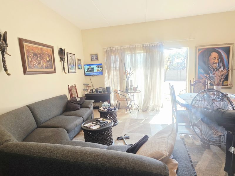 Open plan living and dining area featuring tiled flooring and a large sliding glass door providing access to the outdoor space.