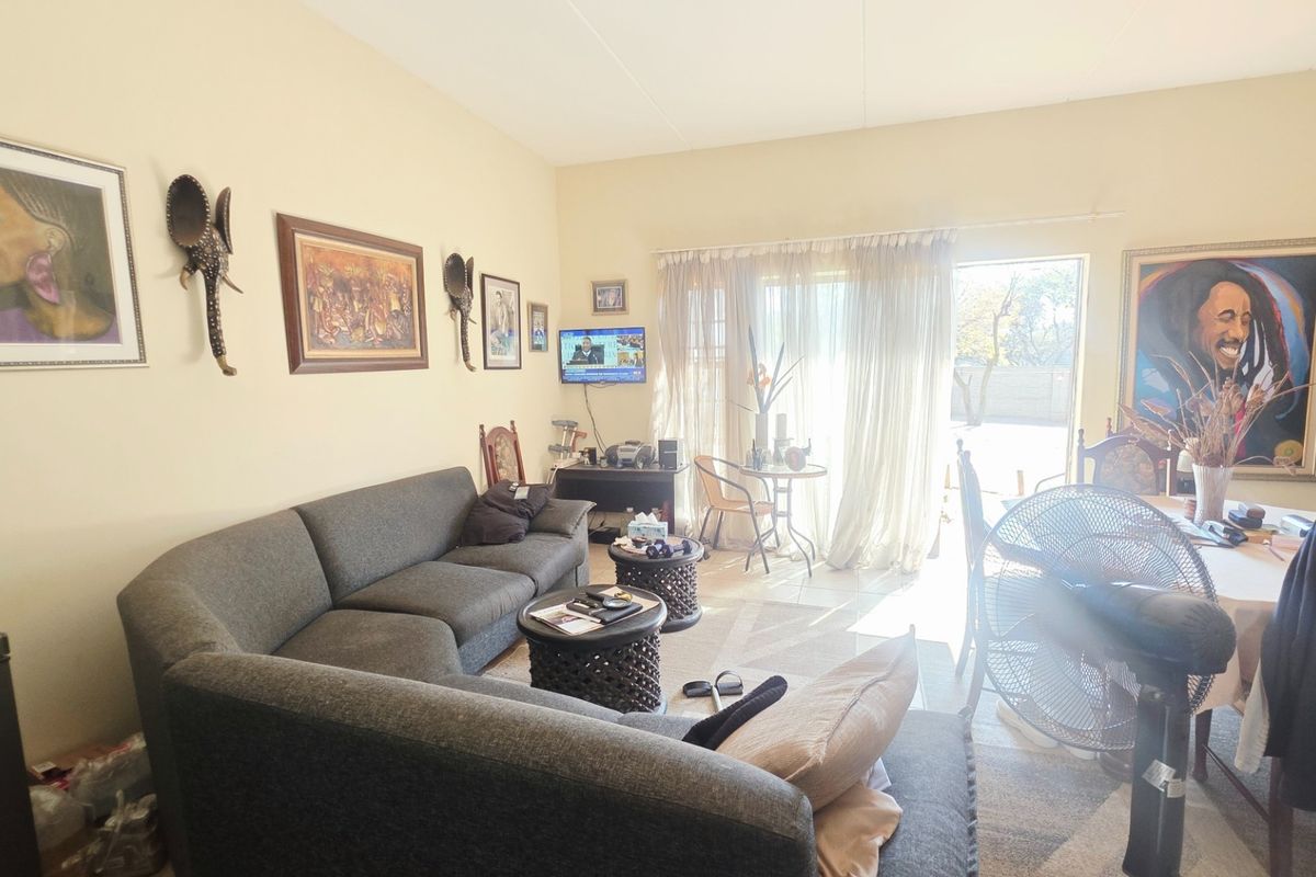 Open plan living area featuring tiled flooring and a sliding glass door providing access to the outdoor space.