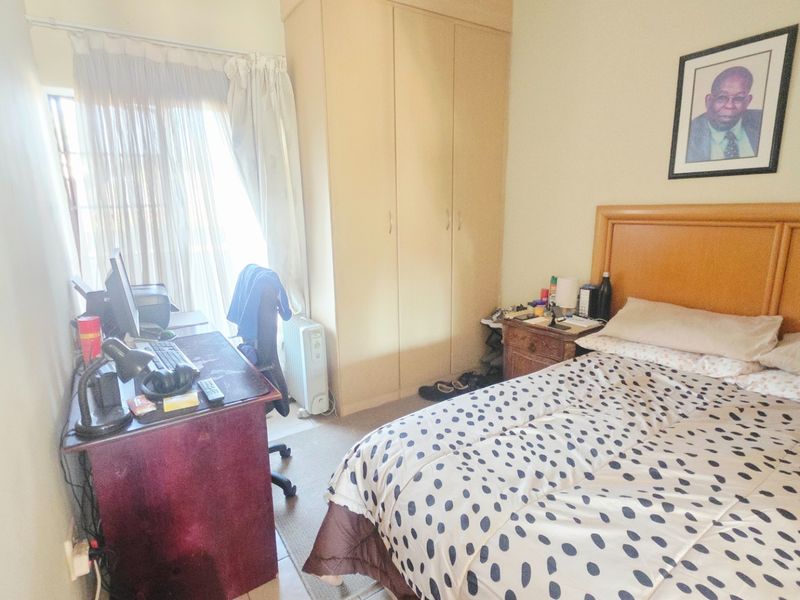 A functional bedroom featuring a built-in wardrobe and a sliding door providing access to the exterior.