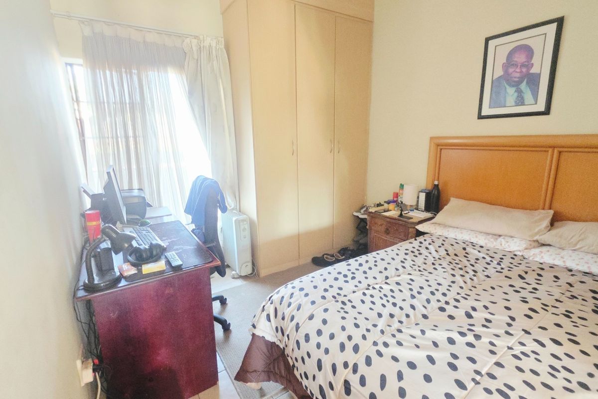 A functional bedroom featuring a built-in wardrobe and a sliding door providing access to the exterior.
