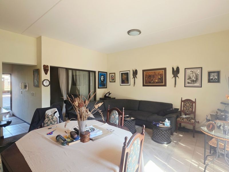 Open plan living and dining area featuring tiled flooring and a sliding glass door leading to an outdoor space.