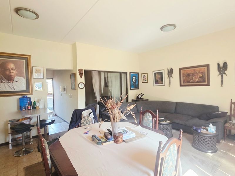 Open plan living and dining area featuring tiled flooring, neutral walls, and direct access to an outdoor patio through sliding glass doors.