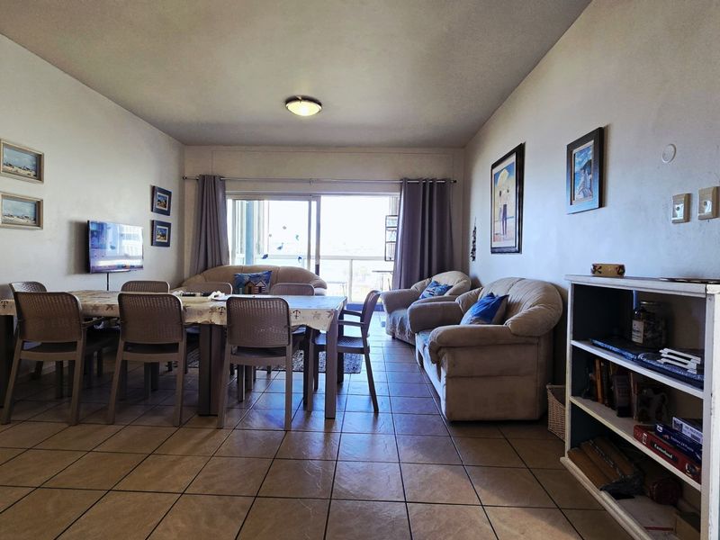 Open plan living and dining area featuring tiled flooring and a large sliding glass door providing access to the balcony.