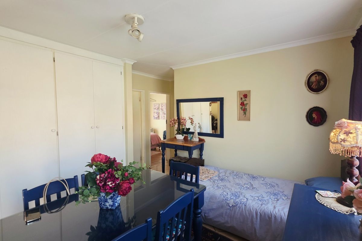 A bedroom featuring built-in cupboards and coved cornicing, offering a functional space with neutral wall finishes.