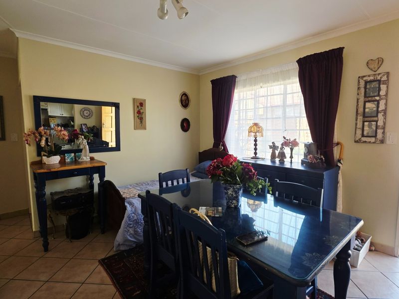 Dining area featuring tiled flooring and direct access to the rear garden through a sliding glass door.