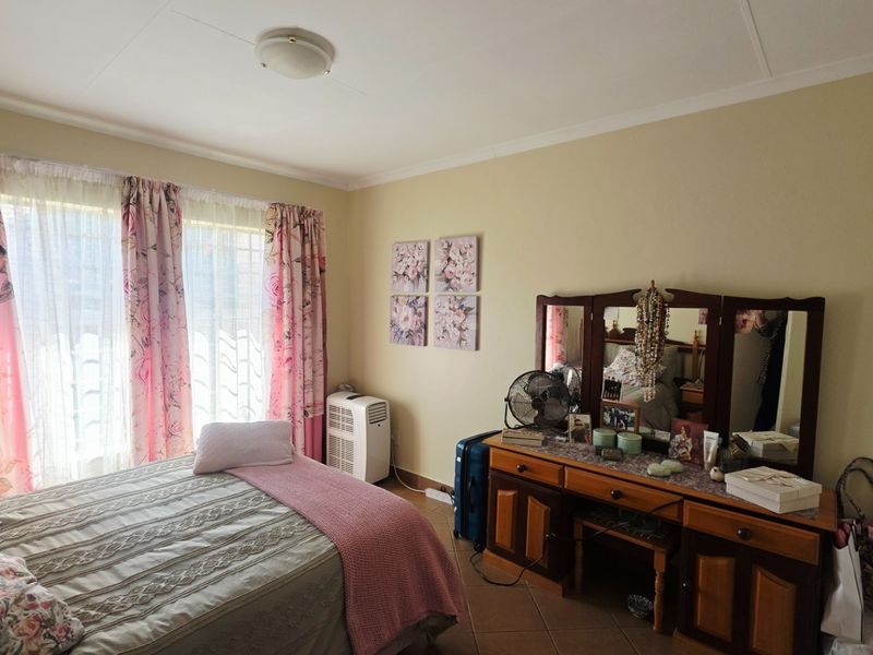 A bedroom featuring tiled flooring and a sliding glass door providing natural light.
