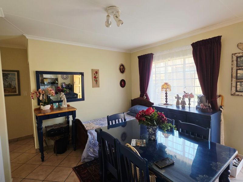A living area featuring tiled flooring and natural light, providing a functional space for relaxation or dining.