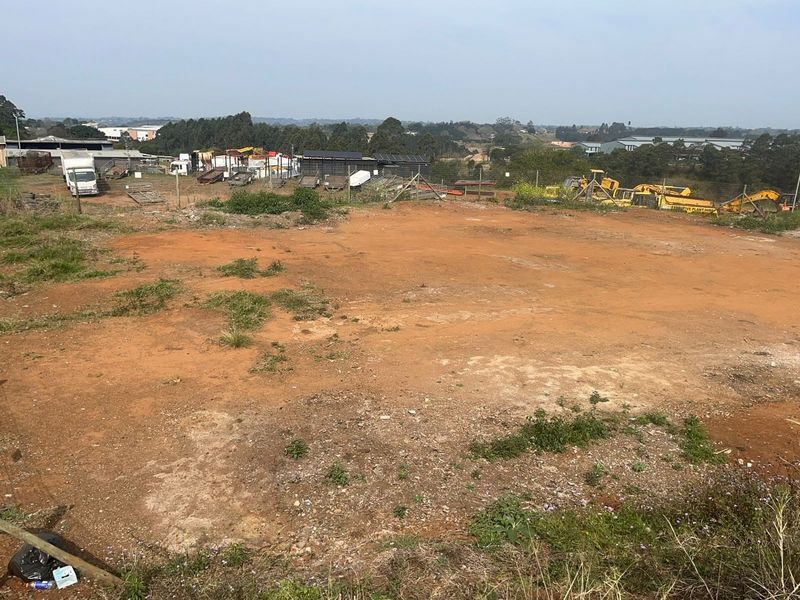 An expansive, cleared agricultural land plot featuring open terrain and perimeter wire fencing, suitable for various development or agricultural purposes.
