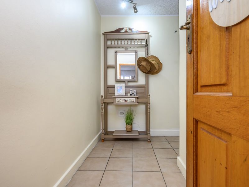 A functional entryway featuring tiled flooring, a solid wood door, and overhead track lighting, providing a clean and welcoming transition into the apartment.