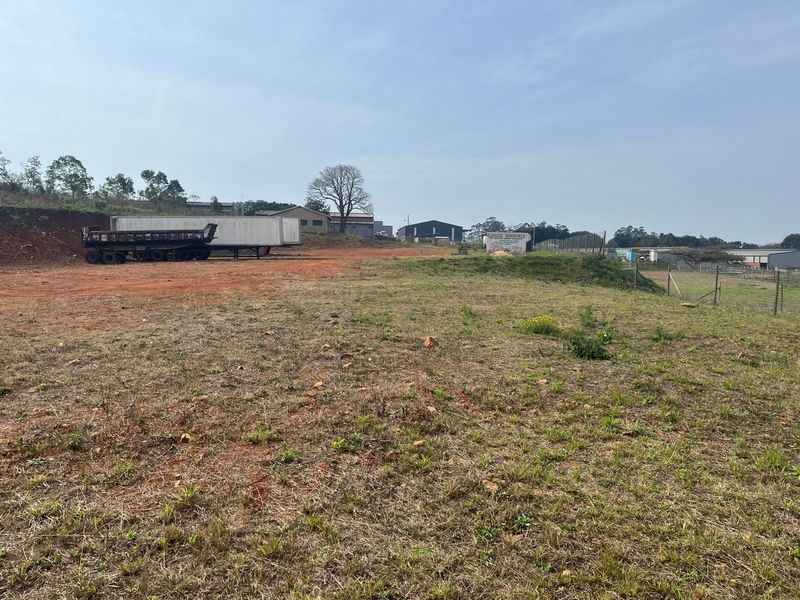 An expansive, open agricultural land plot featuring cleared terrain and perimeter wire fencing, suitable for various development or agricultural purposes.