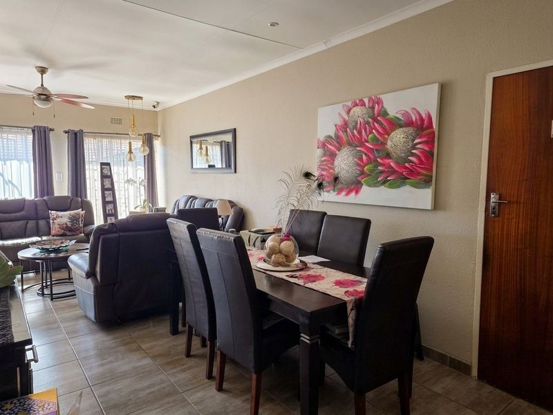Open plan living and dining area featuring tiled flooring, a ceiling fan, and sliding door access to the exterior.