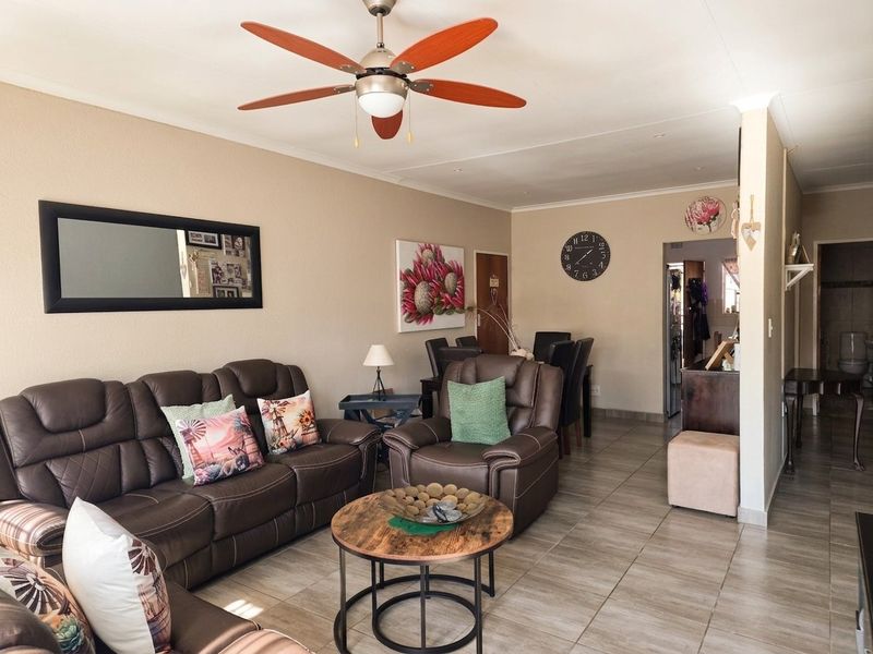 Open plan living and dining area featuring tiled flooring and a central ceiling fan, providing a functional and connected layout.