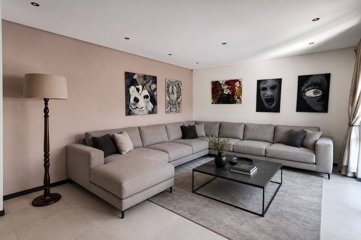 A modern, well-maintained living room featuring neutral tiled flooring, recessed downlighting, and a spacious layout with a feature accent wall.