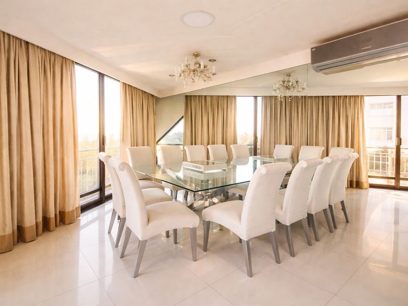 Spacious dining room featuring large glass sliding doors, tiled flooring, a wall-to-wall mirror, and a split-system air conditioning unit.