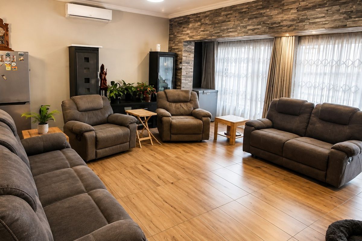 Spacious living room featuring modern tiled flooring, a stone veneer accent wall, and large sliding glass doors providing ample natural light.