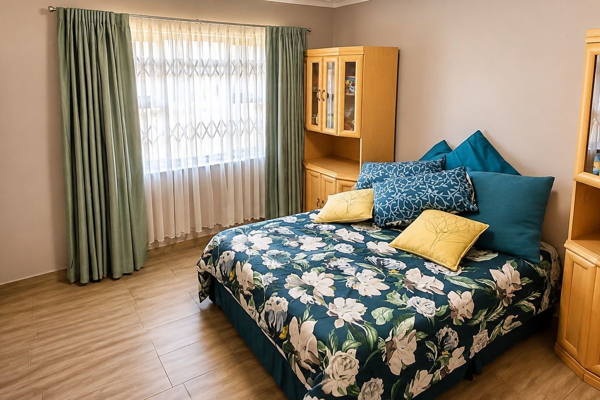 A well-maintained bedroom featuring light-toned tiled flooring and a window fitted with a security gate, offering a clean and functional living space.