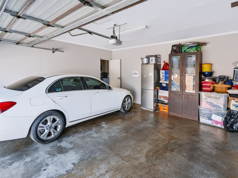 A functional double garage featuring a sectional door, automatic opener, and durable concrete flooring with direct access to the interior.