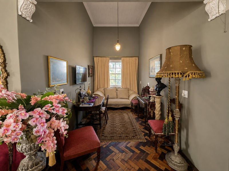 A character-filled living space featuring high ceilings with decorative corbels and classic herringbone timber flooring, offering a warm and traditional aesthetic.