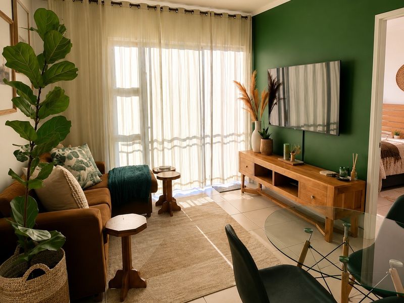A bright and well-maintained living room featuring tiled flooring and a large sliding glass door that provides ample natural light.