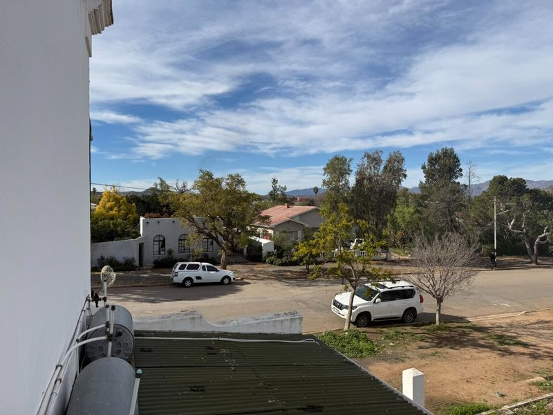 Elevated view overlooking the street and surrounding neighbourhood, featuring a visible external electric geyser and corrugated roof structure.