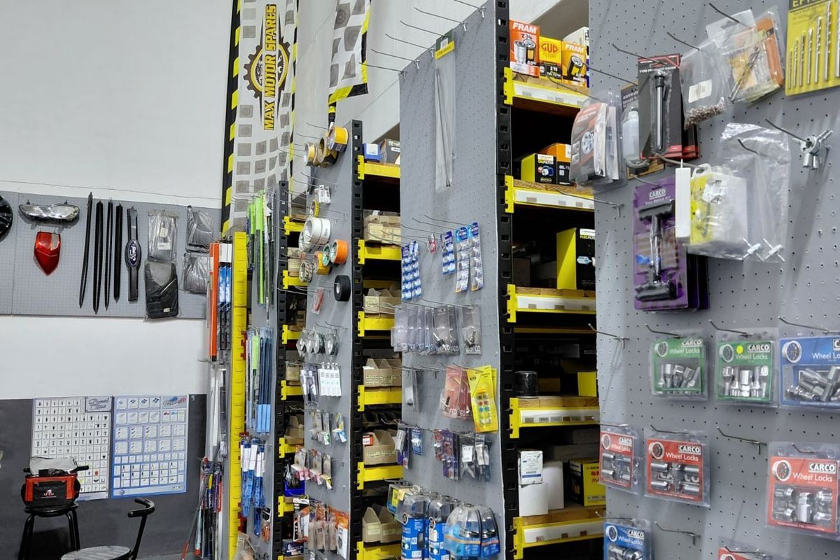 Commercial retail space featuring industrial metal shelving units and pegboard display panels for organized product storage and presentation.