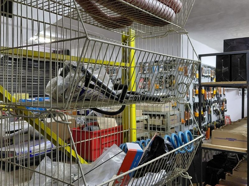 A commercial utility or storage space featuring industrial metal shelving units and wall-mounted pegboard systems for organized inventory storage.