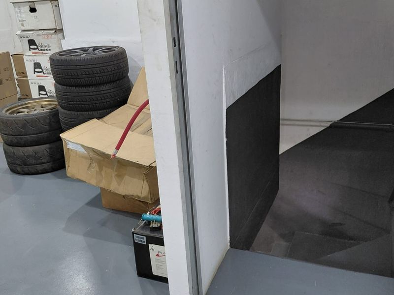 A utility space featuring an epoxy floor and a staircase leading to a lower level.