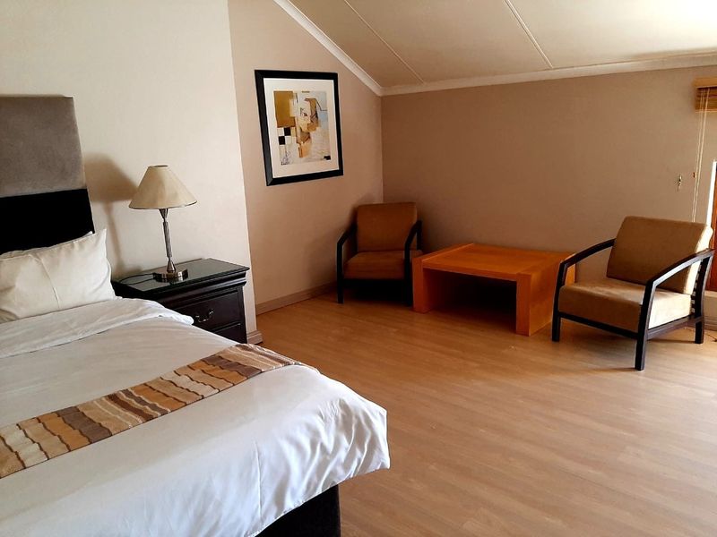 A bedroom featuring laminate flooring and a sloped ceiling, providing a comfortable and functional living space.