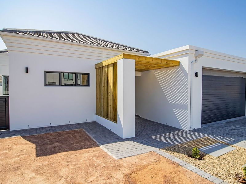 Modern front elevation featuring a paved driveway, integrated garage, timber pergola entrance, and clean white rendered facade with contemporary architectural detailing.