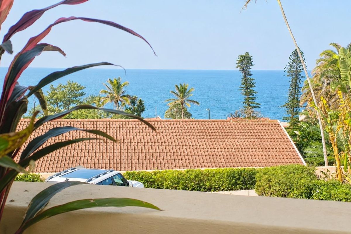 A scenic elevated view of the ocean and surrounding coastal landscape captured from a balcony.