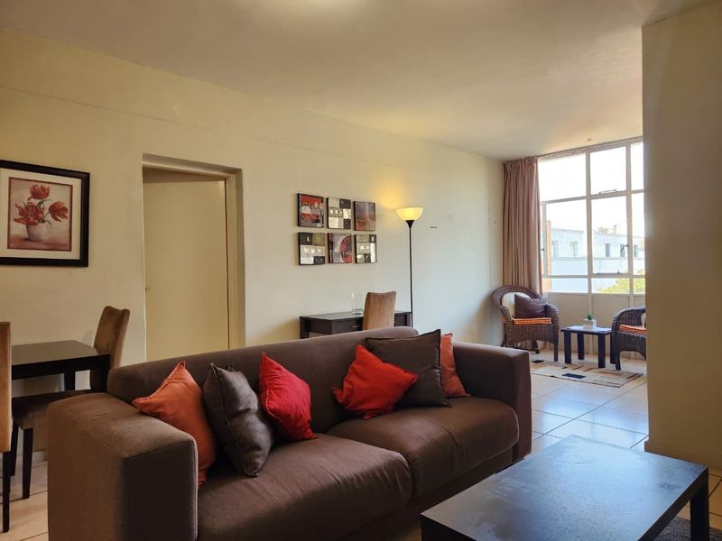 Spacious living area featuring tiled flooring and large windows that provide ample natural light, creating a bright and inviting atmosphere.