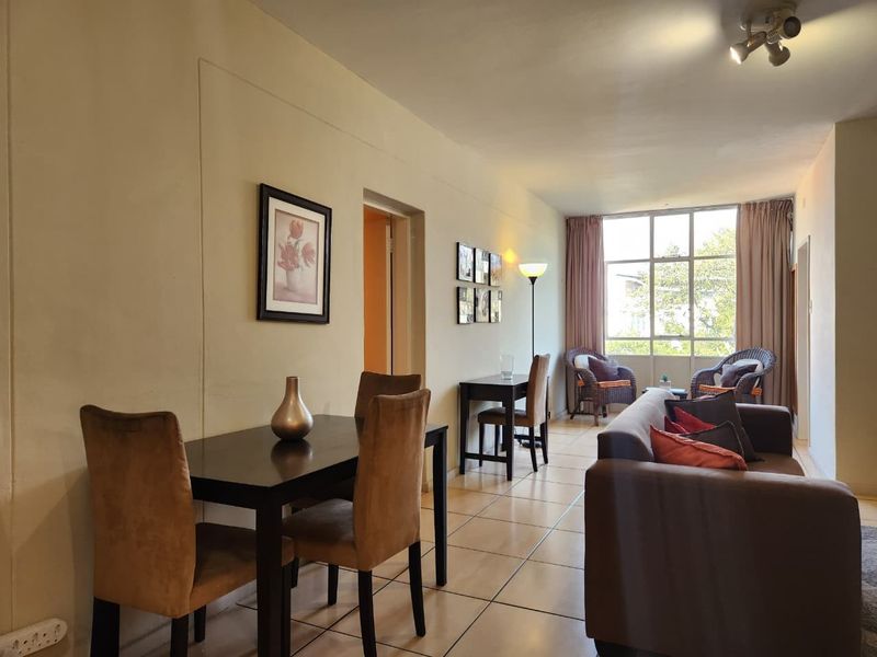 Open plan living and dining area featuring tiled flooring and large windows allowing for natural light.
