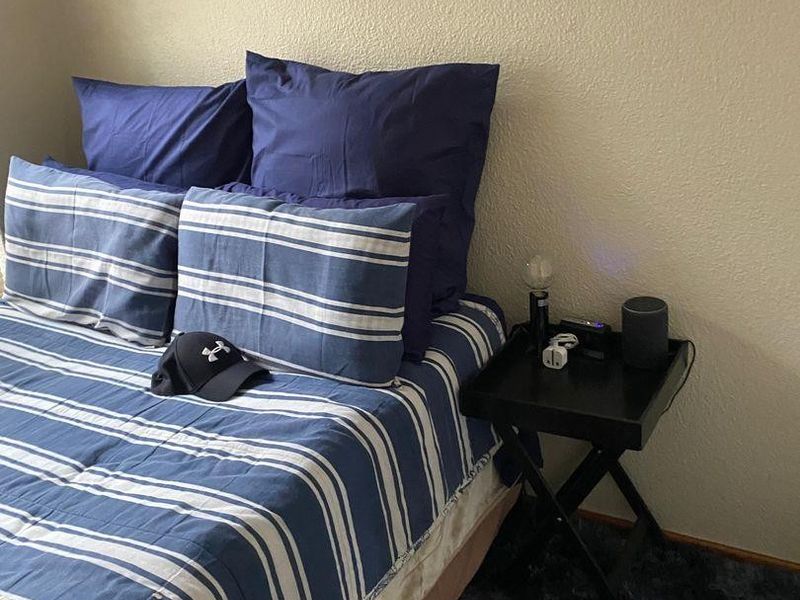 A bedroom space featuring neutral wall finishes and carpeted flooring.