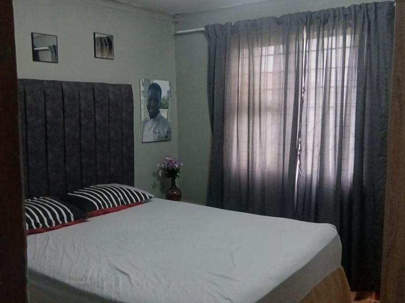 A standard bedroom featuring tiled flooring and window treatments, providing a functional sleeping space.